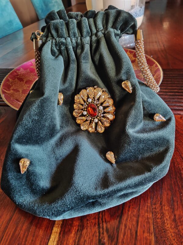 Este bolso bombonera es la combinación perfecta de lujo y sofisticación, diseñado para quienes buscan destacar en eventos y celebraciones especiales. Confeccionado en terciopelo verde, su textura suave y su color profundo añaden un toque de elegancia que lo convierte en el accesorio ideal para fiestas, bodas o cualquier ocasión que demande estilo.