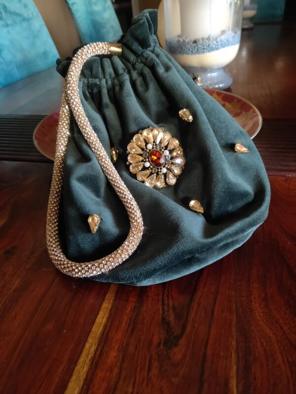 Este bolso bombonera es la combinación perfecta de lujo y sofisticación, diseñado para quienes buscan destacar en eventos y celebraciones especiales. Confeccionado en terciopelo verde, su textura suave y su color profundo añaden un toque de elegancia que lo convierte en el accesorio ideal para fiestas, bodas o cualquier ocasión que demande estilo.