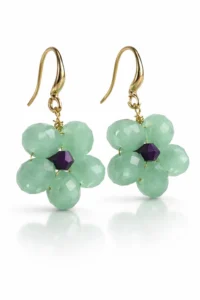 Pendientes colgantes artesanales con cuentas verde menta y detalle morado, gancho dorado, fotografía de producto en fondo blanco